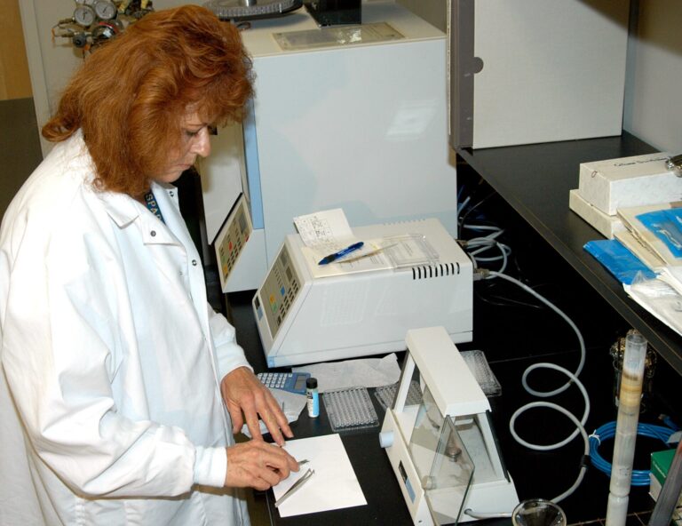 reproducibility crisis science — A scientist in a laboratory conducting experiments, representing the challenges of reproducible research.